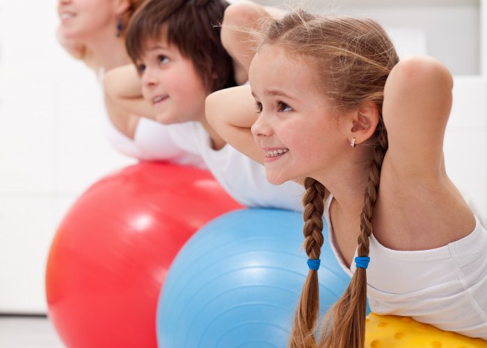 Three children exrercising during a PE class